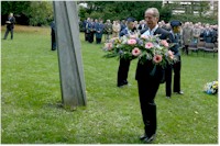 Piet Van Hecke begeeft zich met zijn bloemenkrans naar het monument.
